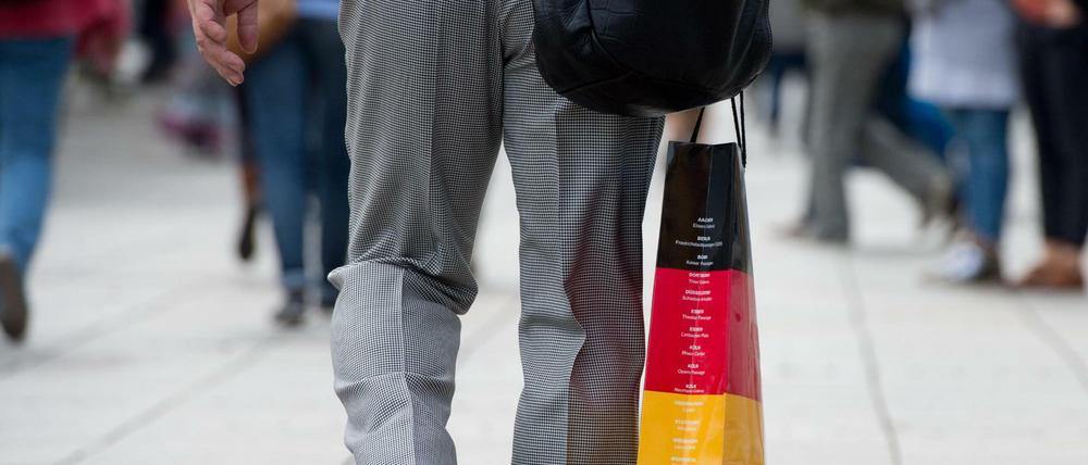 Ein Mann trägt eine Tasche in den deutschen Nationalfarben.