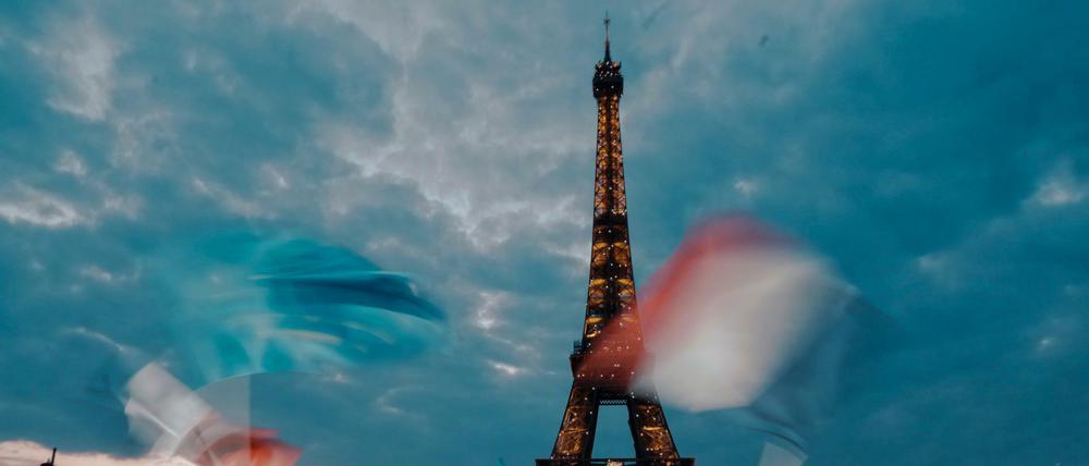 Anhänger des französischen Präsidenten Emmanuel Macron feiern am Eiffelturm mit Landesflaggen. 