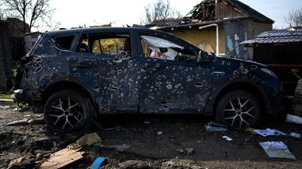 Ein von Einschusslöchern durchlöchertes Auto steht am Straßenrand in Butscha.