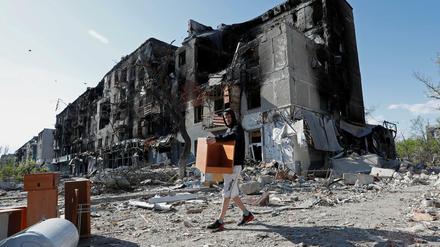 Ein Mann rettet Möbel aus einem zerstörten Haus in Mariupol.
