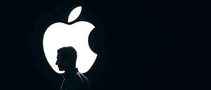 Eine Person steht vor dem Apple-Logo.