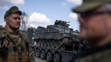 Bundeswehrsoldaten der Nato-Einsatzgruppe in Litauen vor einem Schützenpanzer Marder.