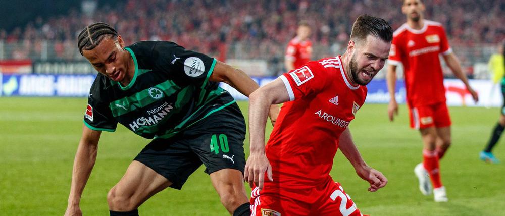 Schmerzhaftes Ergebnis. Jamie Leweling (l.) foult in dieser Szene Unions Niko Gießelmann. Die Köpenicker taten sich gegen die bereits als Absteiger feststehenden Fürther sehr schwer und durften sich über das 1:1 am Ende nicht einmal beschweren.