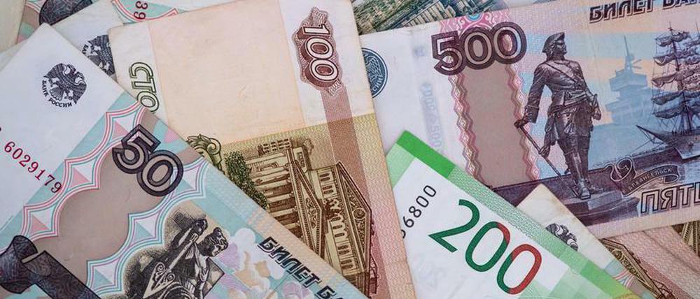 Russische Rubel-Banknoten liegen auf einem Tisch. Entgegen vorheriger Aussagen hat Russland die Bonds doch in Dollar statt in Rubel bedient.