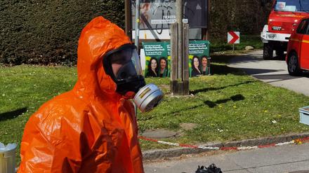 Ein Feuerwehrmann im ABC Schutzanzug steht in der Nähe der Freilichtbühne in Lübeck, wo es einen Zwischenfall gegeben hat.