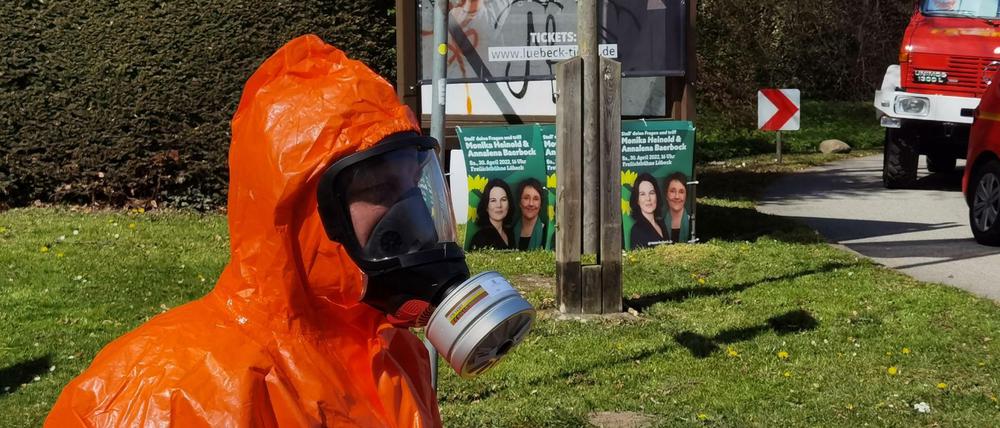 Ein Feuerwehrmann im ABC Schutzanzug steht in der Nähe der Freilichtbühne in Lübeck, wo es einen Zwischenfall gegeben hat.