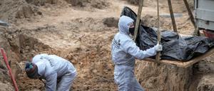 Männer exhumieren Leichen von Zivilisten, die während der russischen Besatzung in Butscha getötet wurden (Archivbild).