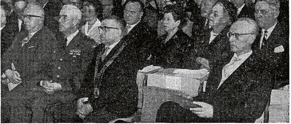 Auf einem historischen Zeitungsfoto sitzen festlich gekleidete Männer und Frauen bei einer Feierstunde in einem Hörsaal.