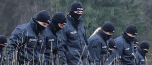 Polizeibeamte suchen auf einer Wiese in Memmingerberg nach Spuren.