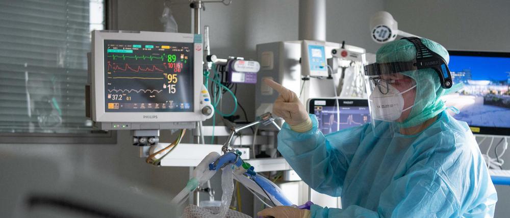 Eine Intensiv-Pflegerin versorgt einen schwer an Corona erkrankten Patienten. 