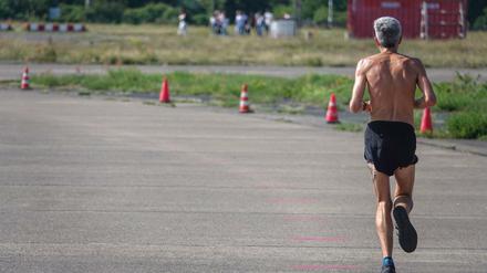 Die Sonne brennt. Ein Mann joggt auf dem Tempelhofer Feld.