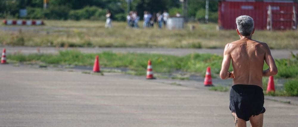 Die Sonne brennt. Ein Mann joggt auf dem Tempelhofer Feld.