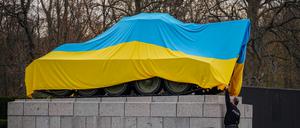 Polizeibeamte entfernen eine ukrainische Flagge von einem Panzer am Sowjetischen Ehrenmal (am 30. März 2022)