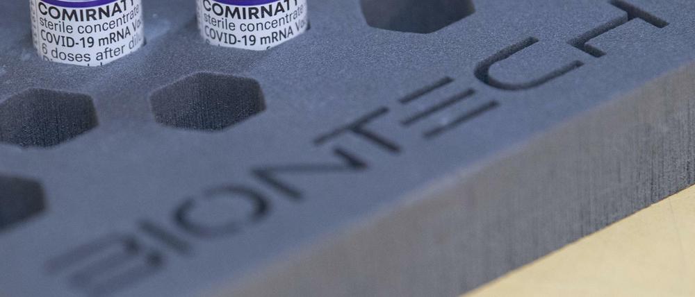 Fläschchen mit dem Biontech-Impfstoff Comirnaty gegen das Coronavirus stehen in einer Schaumverpackung mit Biontech-Schriftzug auf einem Tisch.