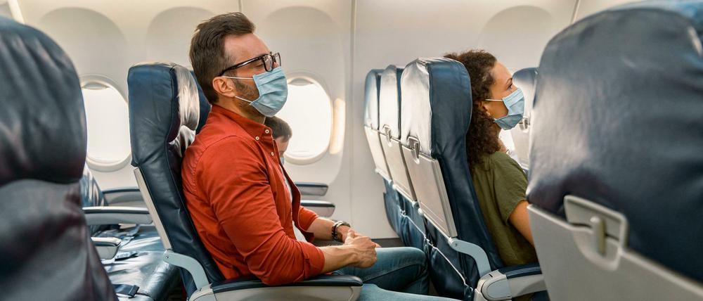 Flugpassagiere tragen Mund-Nasen-Schutz während eines Fluges (Symbolbild)