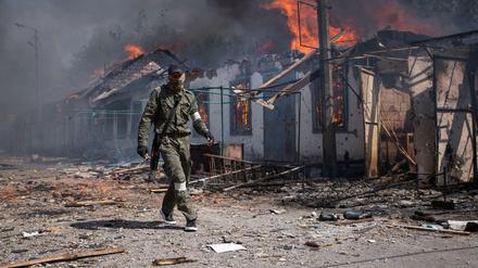 Ein prorussischer Kämpfer vor brennenden Häusern in der Region Luhansk