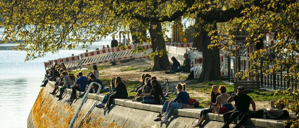 Menschen genießen die Sonne am Landwehrkanal.