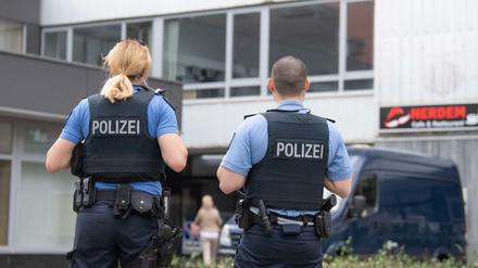 Polizisten stehen vor einem Hochhaus in Hanau, in dem am Vortag zwei Kinder zu Tode gekommen waren.