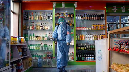Ein Angestellter des Kyonghung Foodstuff General Store desinfiziert den Ausstellungsraum. 