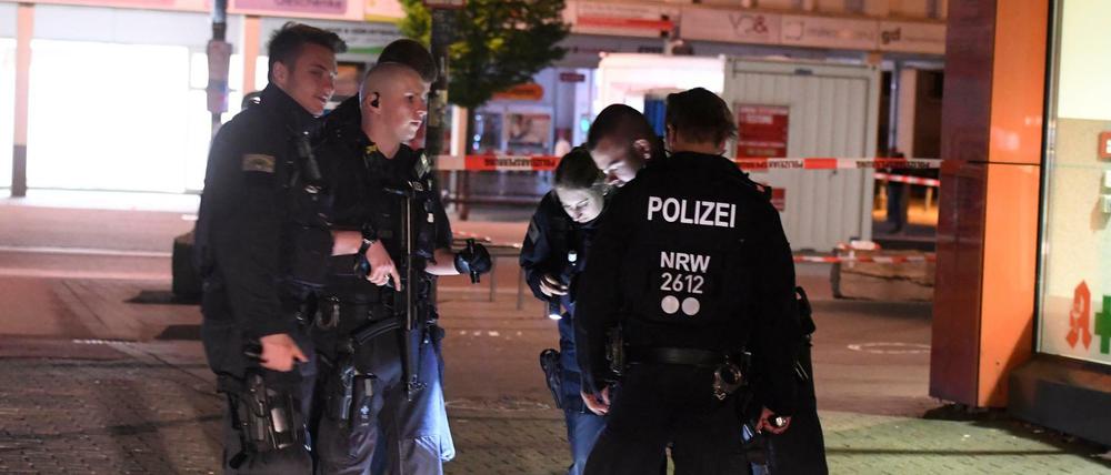 Polizisten suchen in der Nacht nach Spuren der Schießerei auf dem Hamborner Altmarkt in Duisburg.