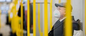 Ein Mann sitzt mit FFP2-Maske in der U-Bahn.