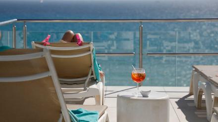Eine Kundin sonnt sich auf der Dachterrasse eines Hotels auf Mallorca. 