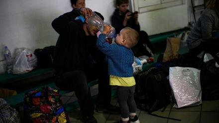 Oleander Kompaniets gibt seinem Sohn Dmytro, in einer Aufnahmestelle für ukrainische Binnenflüchtlinge aus einer Flasche zu trinken.