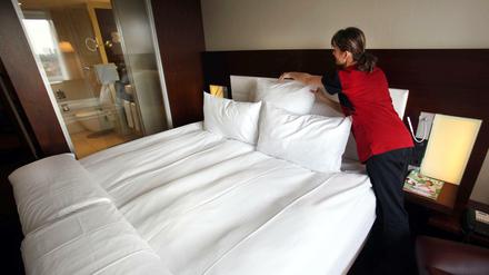 Ein Zimmermädchen macht in einem Hotel das Bett (Symbolbild).