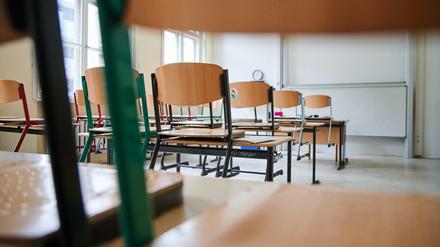 In einem Klassenzimmer stehen die Stühle auf den Tischen. 