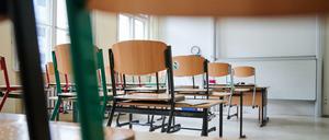 In einem Klassenzimmer stehen die Stühle auf den Tischen. 
