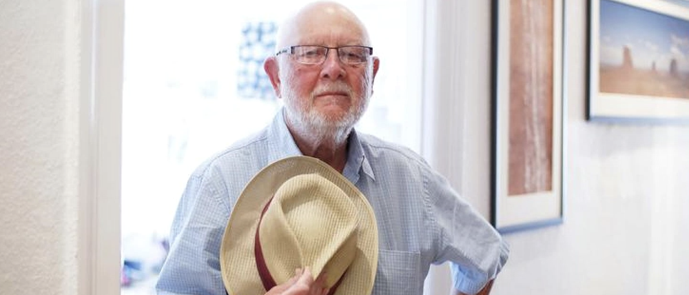 Der Berliner Fotograf Pavel Sticha in seiner Wohnung, einen Strohhut in der Hand.