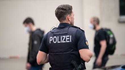 Ein Polizist steht vor dem Gymnasium in Bremerhaven: Einsatzkräfte der Polizei begleiten die Schülerinnen und Schüler aus der Schule.