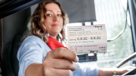 Eine Hamburger Busfahrerin präsentiert ein 9-Euro-Ticket des HVV. 