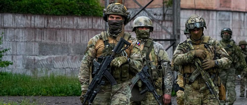 Russische Soldaten gehen durch einen zerstörten Bereich des Stahlwerks Mariupol.