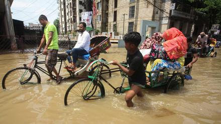 Rikscha-Fahrer kämpfen sich in Sylhet in Bangladesch durch überflutete Straßen.