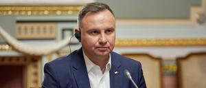 Der polnische Präsident Andrzej Duda hört über Kopfhörer einer Rede von Wolodomir Selenskyj zu. 