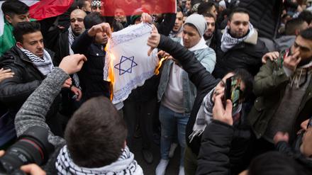 Teilnehmer einer Demonstration in Neukölln verbrennen eine selbstgemalte Fahne mit einem Davidstern. (Archivbild)