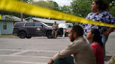Uvalde, Texas: Nach der Bluttat sitzen Menschen am Rande einer Absperrung.