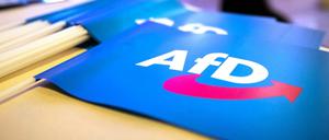 Fähnchen mit dem Logo der AfD liegen auf einem Tisch.