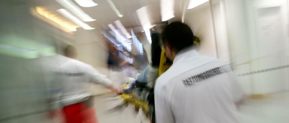 Rettungsassistenten liefern eine Notfallpatientin in ein Krankenhaus.