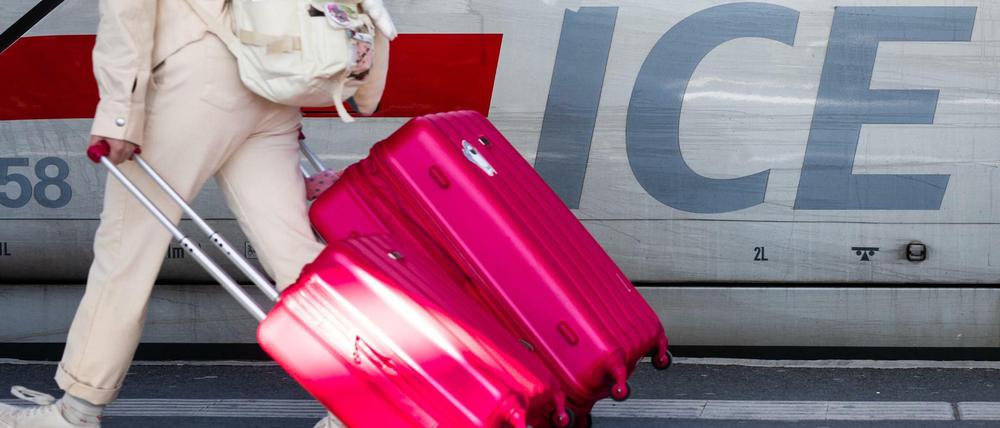 Schneller nach Paris: Eine Frau läuft mit ihren Koffern an einem ICE-Zug der Deutschen Bahn entlang.