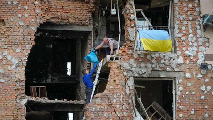 Bewohner holen Habseligkeiten aus einem zerstörten Haus in Irpin.