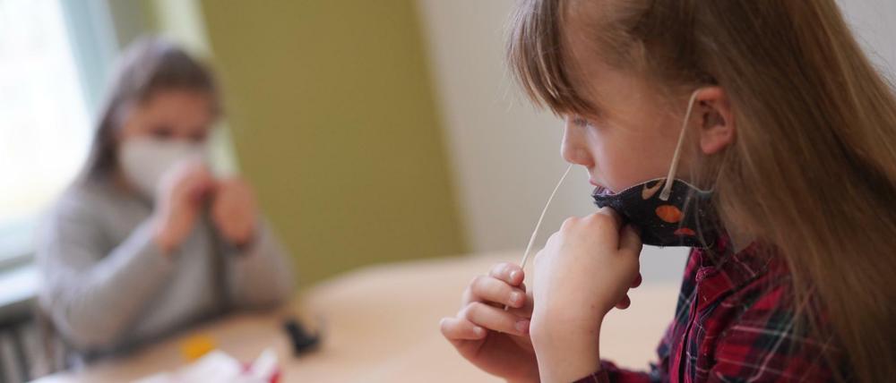 Die Schülerinnen Zeynep (l) und Neele von der Fritz-Karsen-Gemeinschaftsschule führen vor Unterrichtsbeginn einen Corona-Selbsttest durch. Die Berliner Kinder müssen in den Schulen auf das Coronavirus getestet werden.