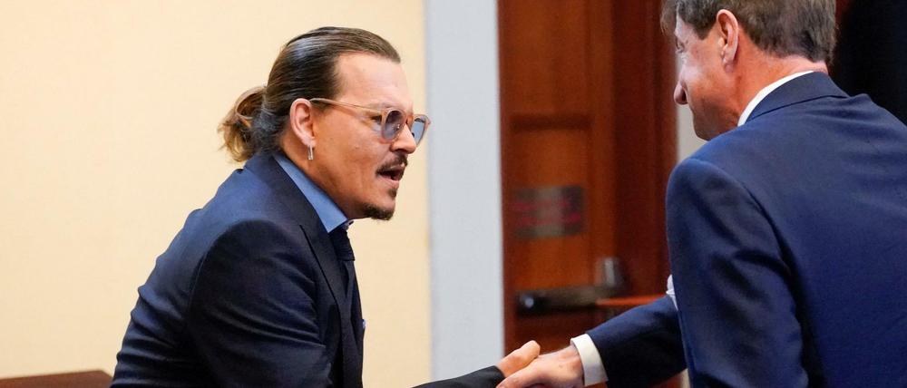 Johnny Depp schüttelt seinem Anwalt die Hand am letzten Tag des Verfahrens zwischen ihm und seiner Ex-Frau Amber Heard.