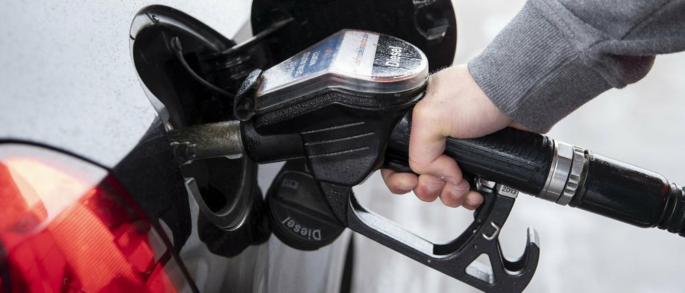 Ein Autofahrer steckt an einer Tankstelle einen Diesel-Zapfhahn in die Tanköffnung seines Fahrzeugs.