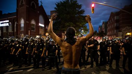 Ein Demonstrant steht während eines Protestes in New York Polizisten gegenüber.