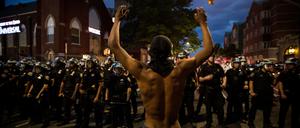 Ein Demonstrant steht während eines Protestes in New York Polizisten gegenüber.