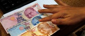Ein Mitarbeiter einer Wechselstube zählt türkische Lira-Banknoten.