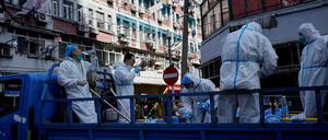 Arbeiter in Schutzanzügen bereiten sich darauf vor, den Lockdown zu beeenden.