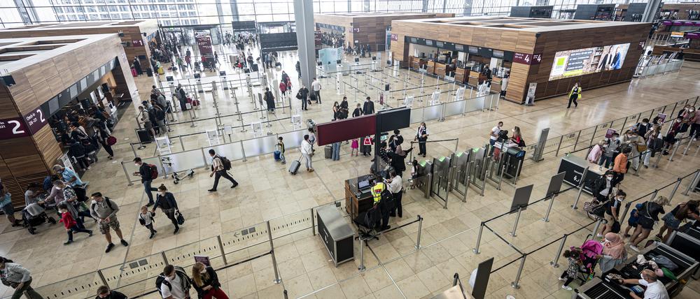 Reisende stehen am Terminal 1 des Flughafen BER. (Symbolbild)